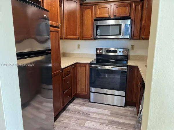 a kitchen with stainless steel appliances granite countertop a stove microwave and refrigerator