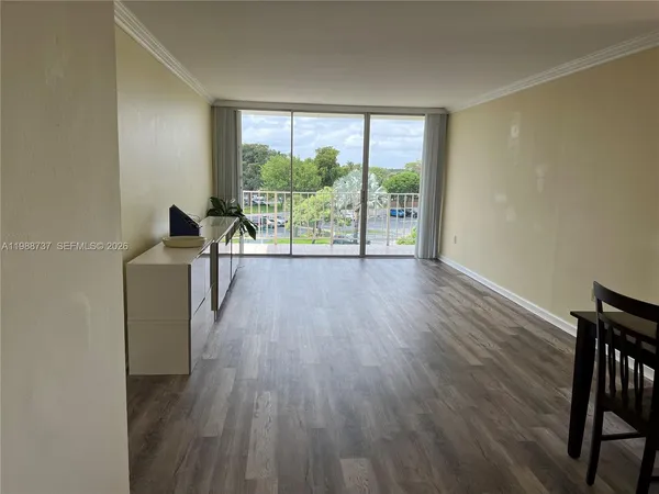 a view of a room with wooden floor and a window