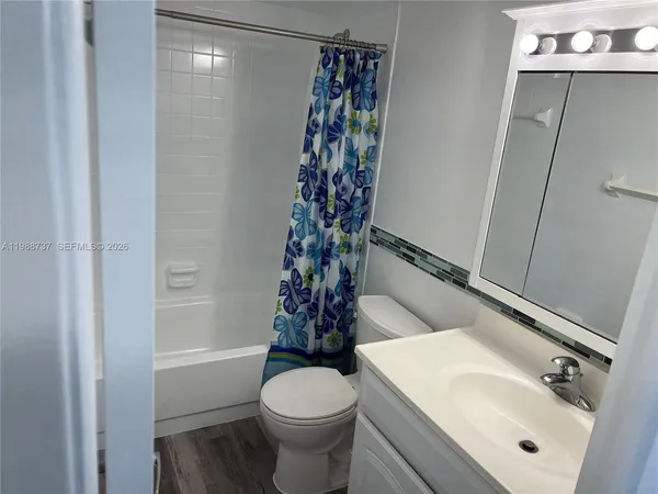 a bathroom with a sink a toilet and shower curtain