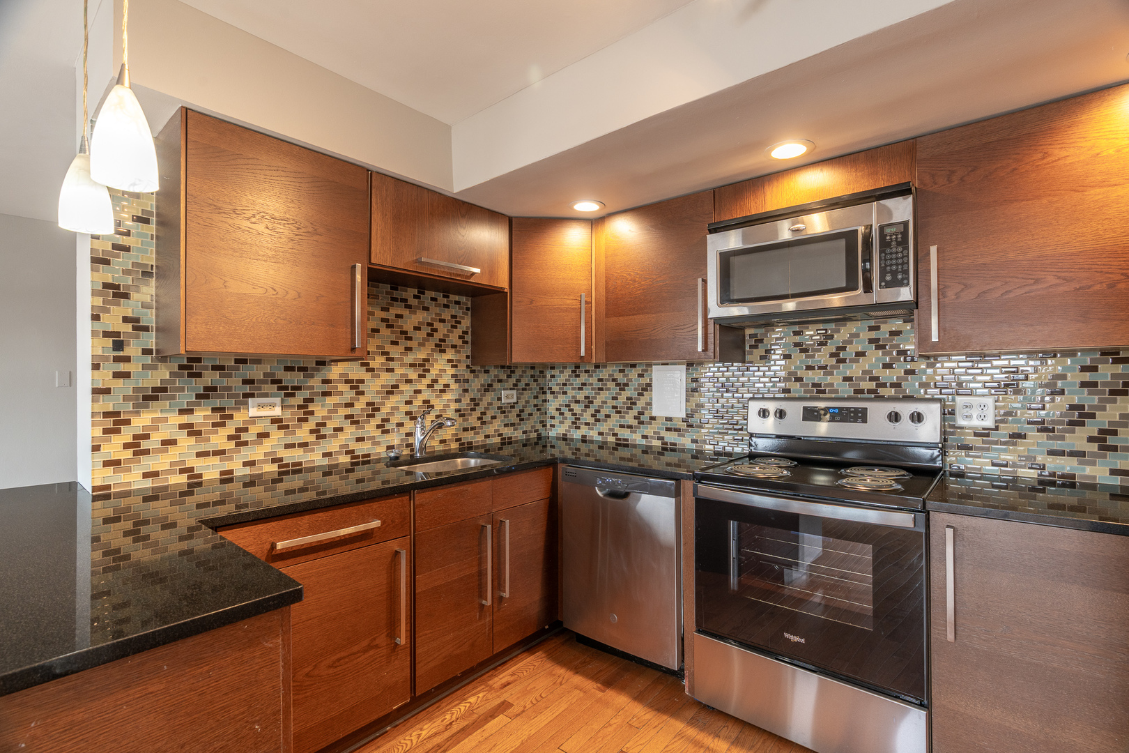 5815 North Sheridan Road, Unit PH2 Chicago, IL 60660 - Photo 2 of 12 a kitchen with stainless steel appliances kitchen island granite countertop a stove a sink and a microwave