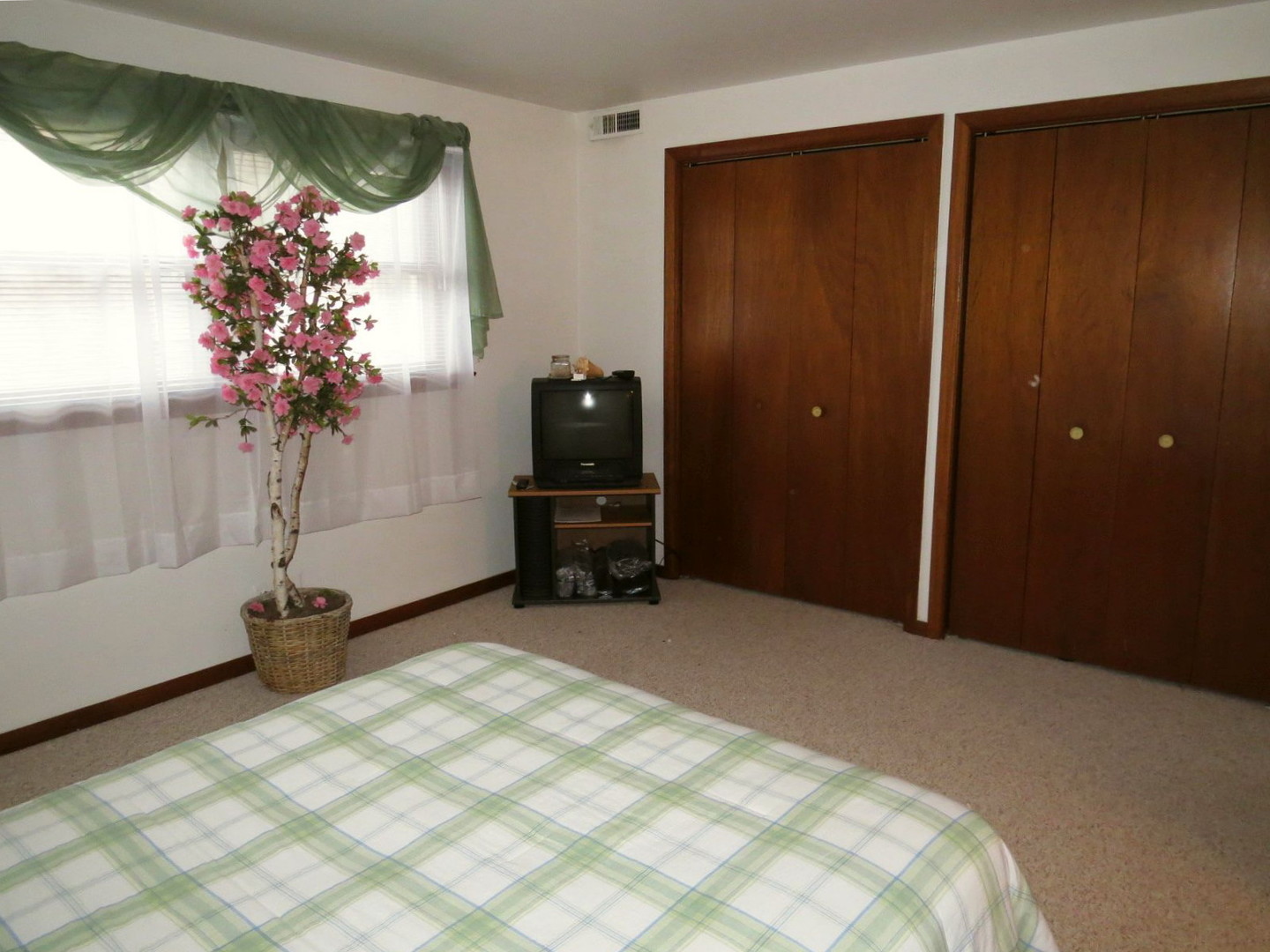 24 North Pistakee Lake Road, Unit 2D Fox Lake, IL 60020 - Photo 23 of 30 a bed room with a bed and a potted plant