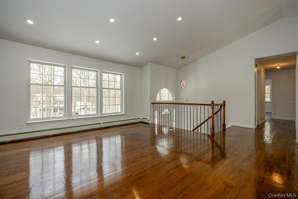 600 Twin Arch Road Rock Tavern, NY 12575 - Photo 7 of 25 Unfurnished room featuring lofted ceiling, baseboard heating, dark wood finished floors, and recessed lighting