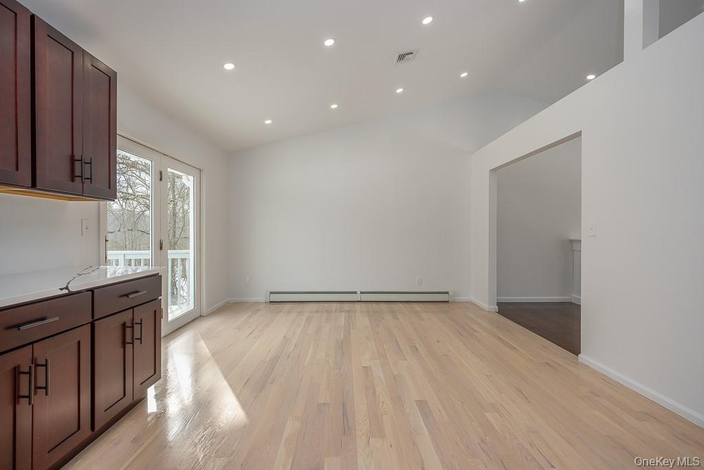 600 Twin Arch Road Rock Tavern, NY 12575 - Photo 9 of 25 Unfurnished dining area featuring light wood-style floors, recessed lighting, a baseboard radiator, and high vaulted ceiling