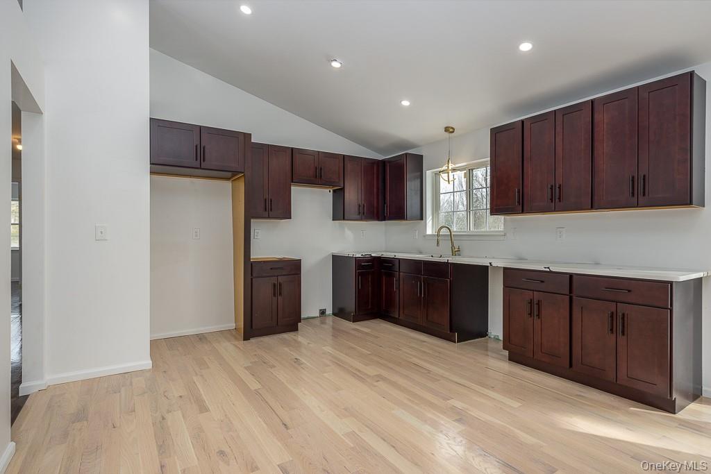 600 Twin Arch Road Rock Tavern, NY 12575 - Photo 10 of 25 Kitchen featuring vaulted ceiling, dark brown cabinets, recessed lighting, light wood-style flooring, and light countertops