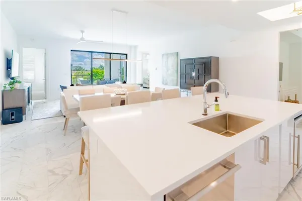 a kitchen with a sink a counter top space and living room
