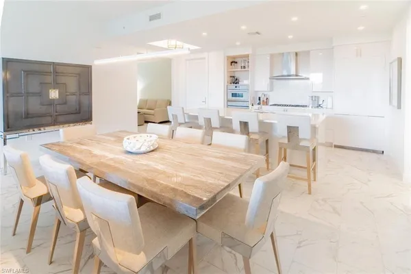 a dining room filled chandelier and kitchen view