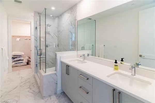a spacious bathroom with a shower sink and a mirror