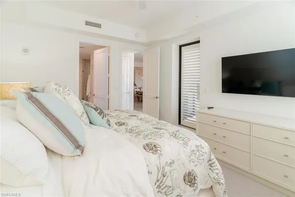a bedroom with a bed and a flat screen tv in the kitchen