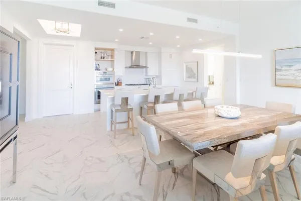 a dining room with kitchen island a table and chairs in it