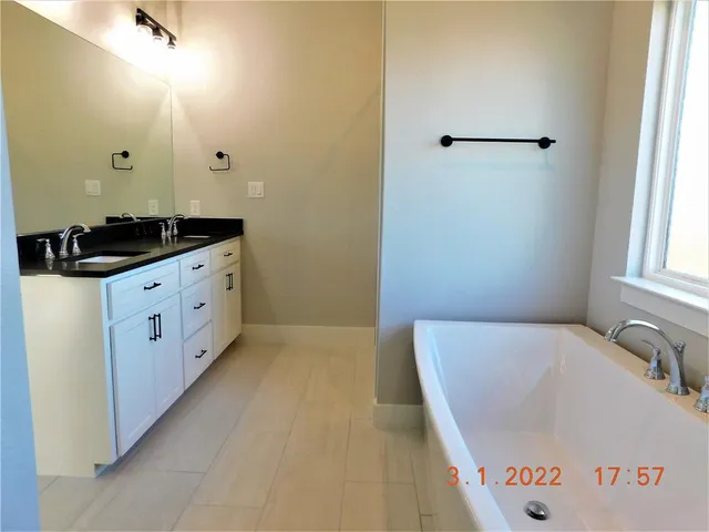 a bathroom with a tub sink and mirror
