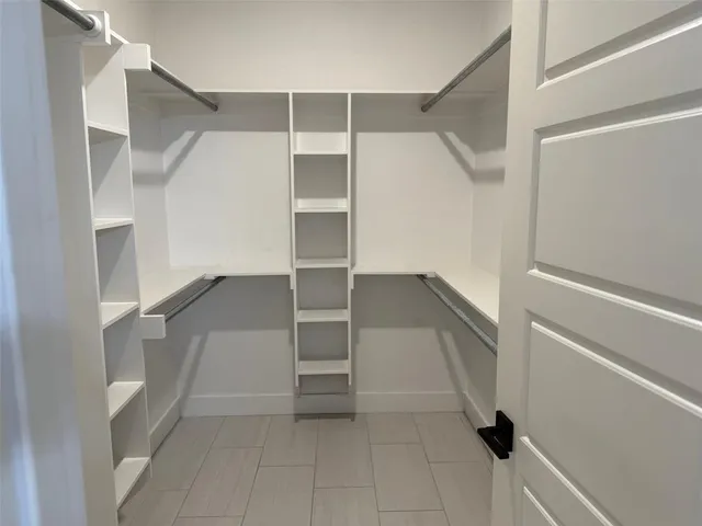 a view of walk in closet with empty racks