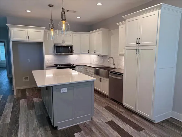 a kitchen with kitchen island a sink stainless steel appliances and cabinets