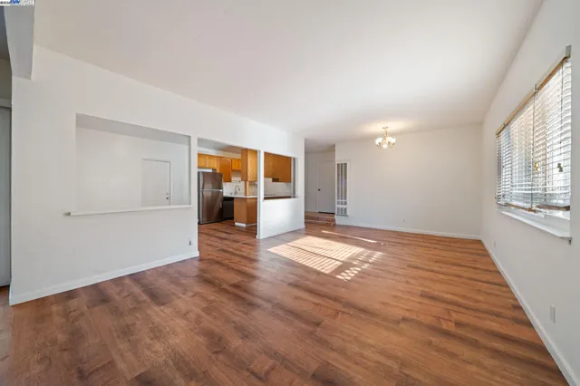 a view of empty room with wooden floor and windows