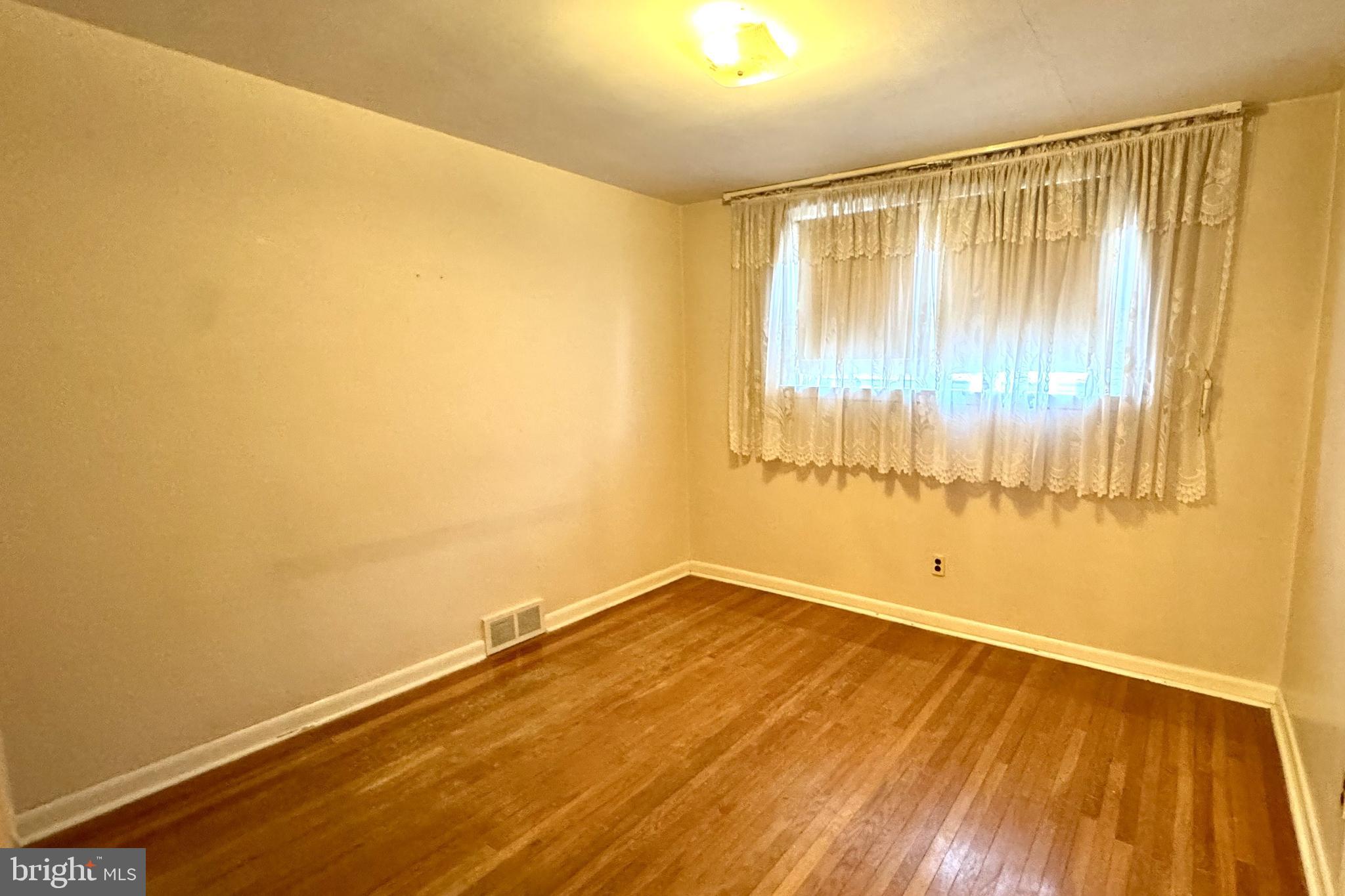 2317 Emerson Street Philadelphia, PA 19152 - Photo 8 of 18 a view of an empty room with wooden floor and a window