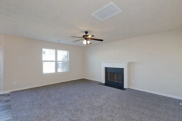 an empty room with fireplace and windows