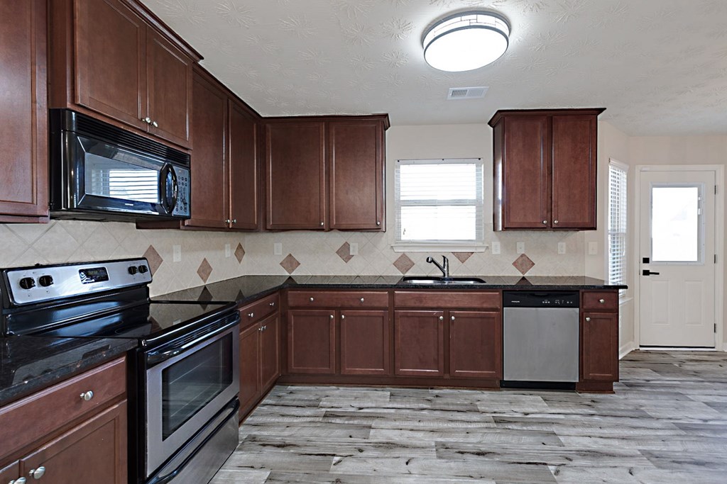18 Memorial Drive Fort Mitchell, AL 36856 - Photo 9 of 33 a kitchen with stainless steel appliances granite countertop a stove a sink dishwasher and a microwave