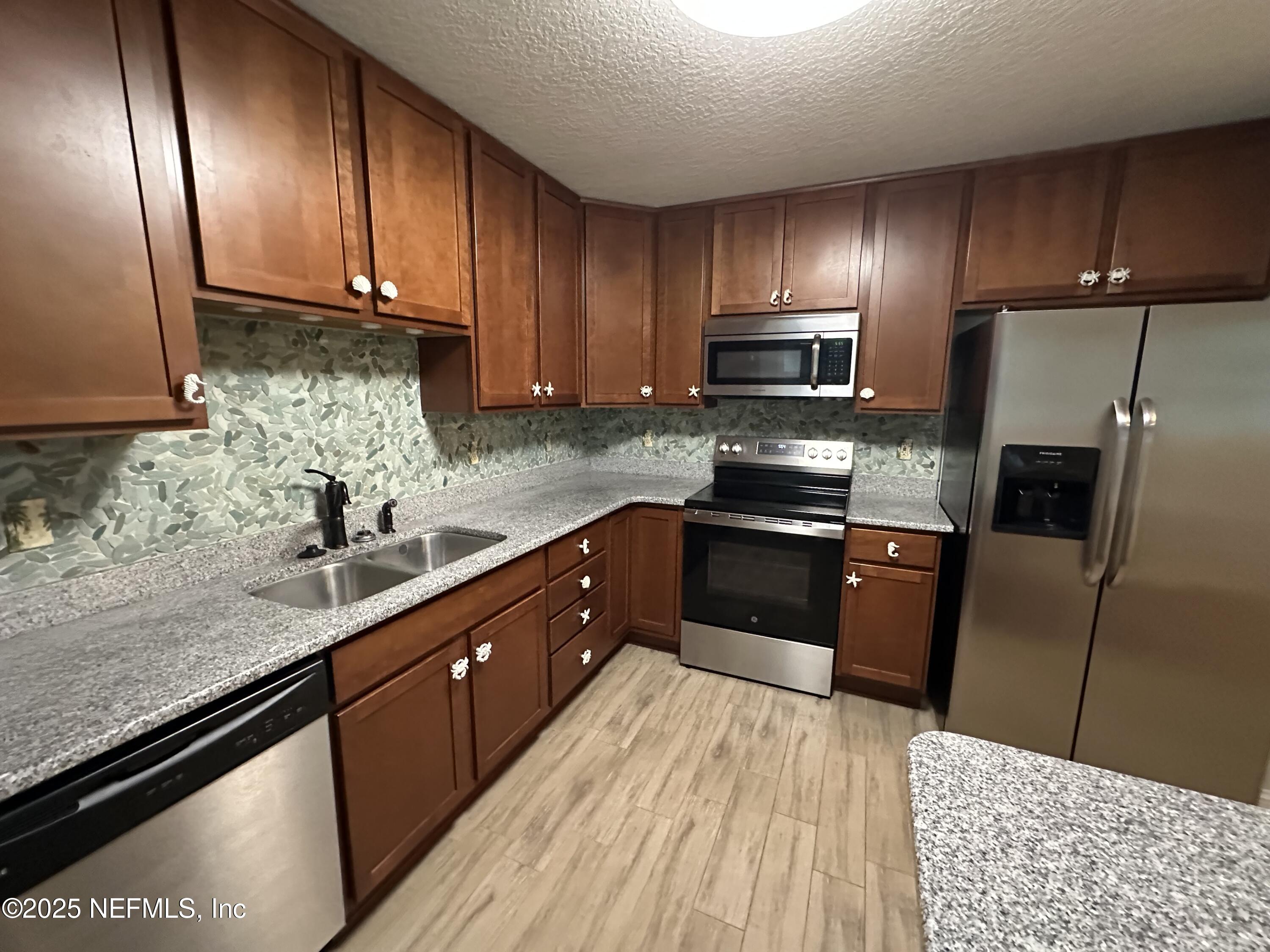 318 Royal Palms Drive Atlantic Beach, FL 32233 - Photo 3 of 39 a kitchen with granite countertop wooden cabinets and stainless steel appliances