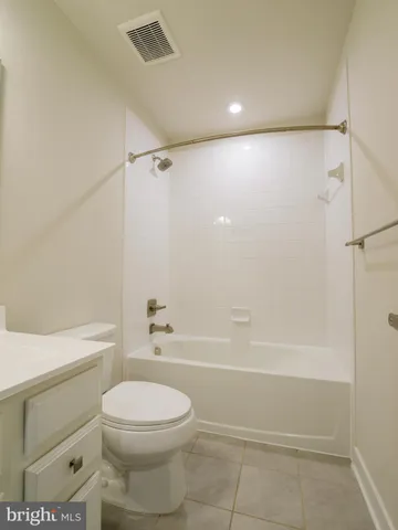 a white toilet sitting next to a bath tub and a shower