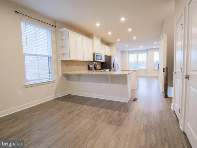 a view of large kitchen with wooden floor and electronic appliances