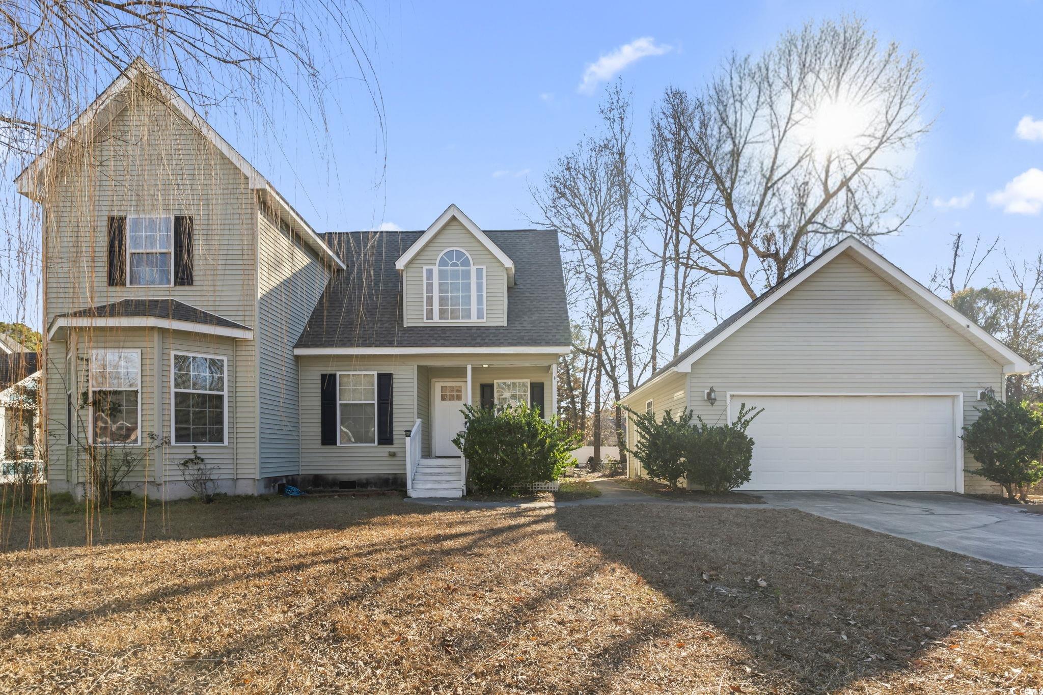 409 Knoll Court Myrtle Beach, SC 29588 - Photo 1 of 33 View of front of house featuring an outbuilding, a garage, roof with shingles, covered porch, and driveway