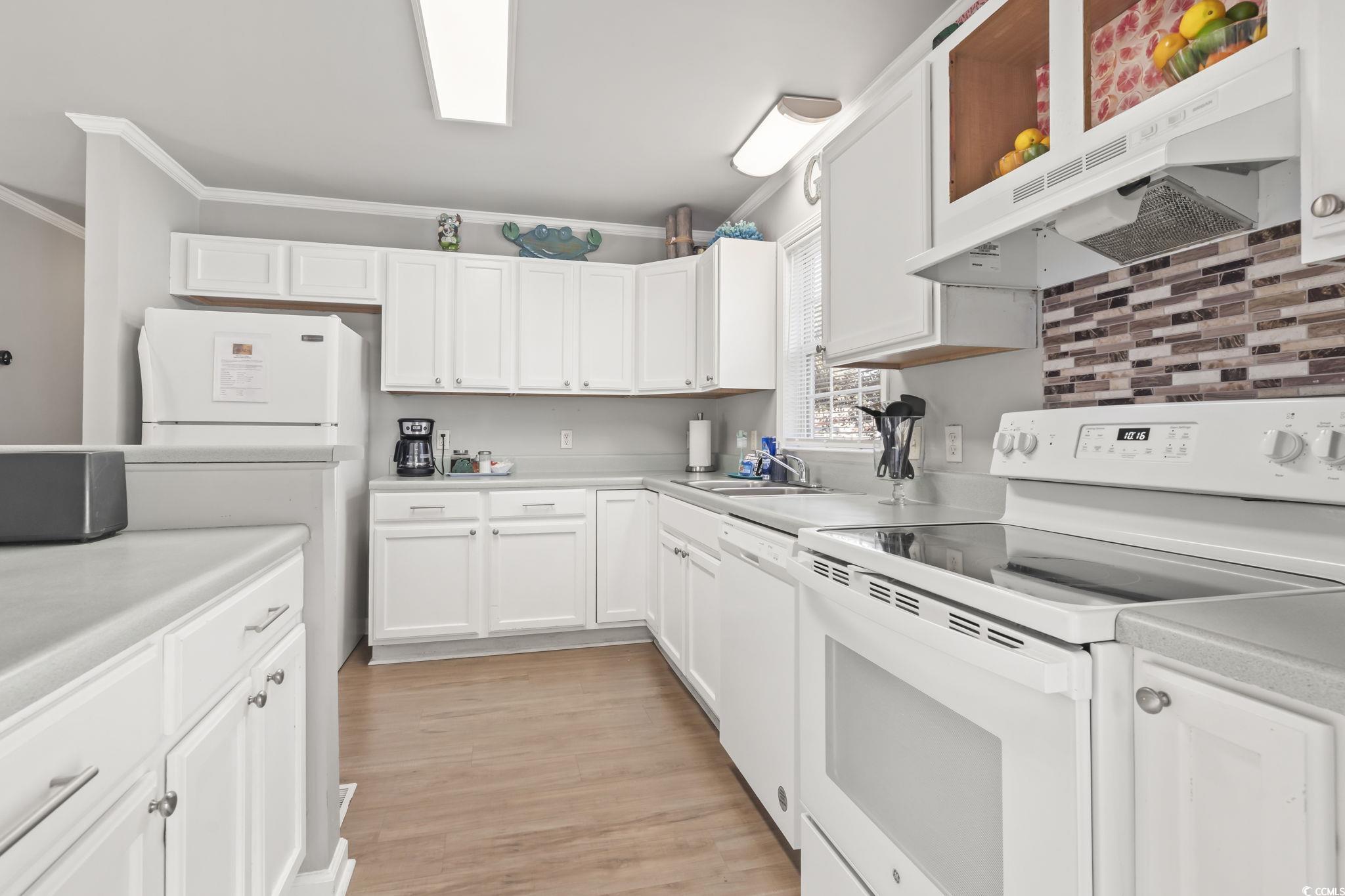 409 Knoll Court Myrtle Beach, SC 29588 - Photo 10 of 33 Kitchen with white appliances, extractor fan, white cabinetry, light countertops, and light wood-style floors