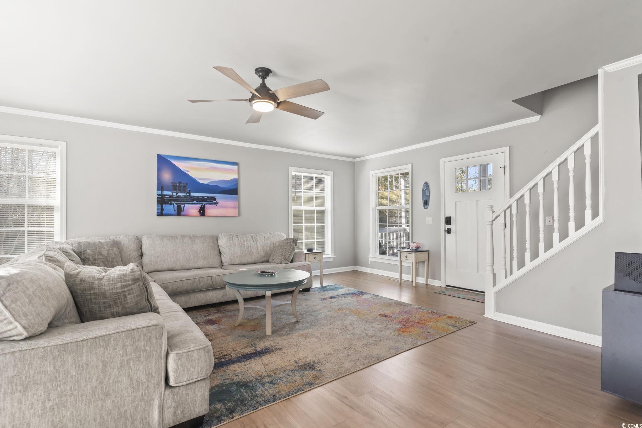 409 Knoll Court Myrtle Beach, SC 29588 - Photo 13 of 33 Living area with stairway, ceiling fan, crown molding, and wood finished floors