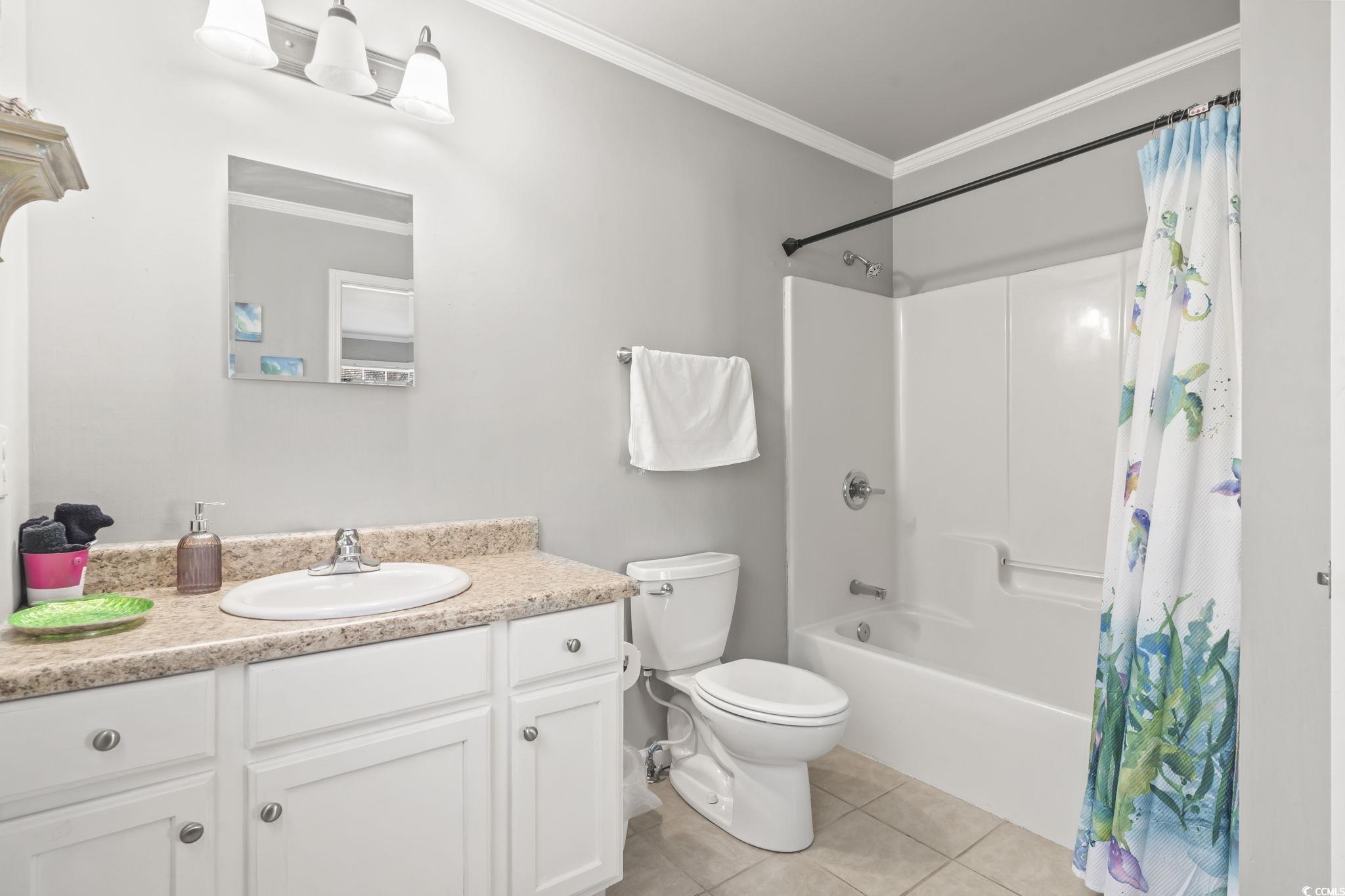 409 Knoll Court Myrtle Beach, SC 29588 - Photo 18 of 33 Bathroom with crown molding, vanity, light tile patterned flooring, and shower / bath combo with shower curtain