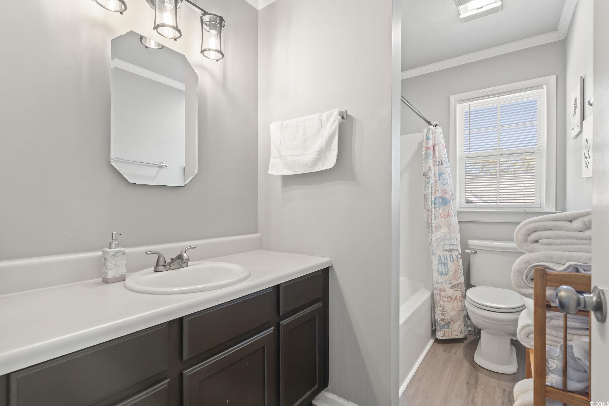 409 Knoll Court Myrtle Beach, SC 29588 - Photo 22 of 33 Full bath with vanity, ornamental molding, shower / bath combo with shower curtain, and light wood finished floors