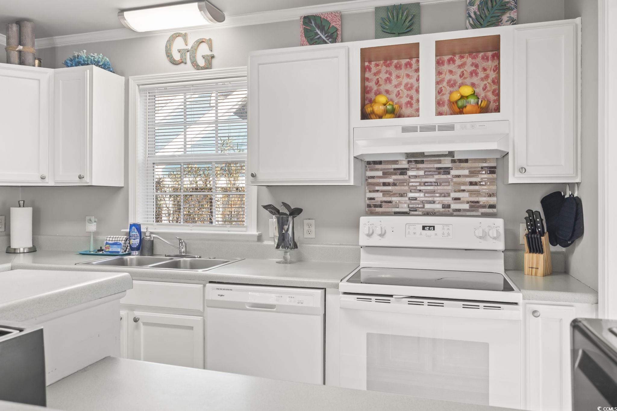 409 Knoll Court Myrtle Beach, SC 29588 - Photo 7 of 33 Kitchen featuring white appliances, light countertops, white cabinetry, under cabinet range hood, and crown molding