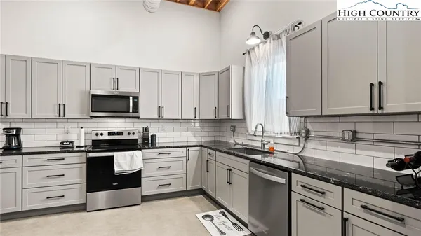 a kitchen with stainless steel appliances a sink a counter and a cabinets