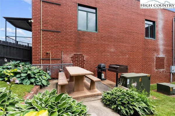 a view of a backyard with potted plants and large tree