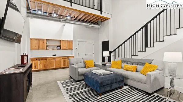 a living room with furniture a rug and white walls