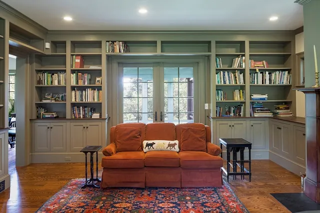a living room with furniture a rug and a book shelf