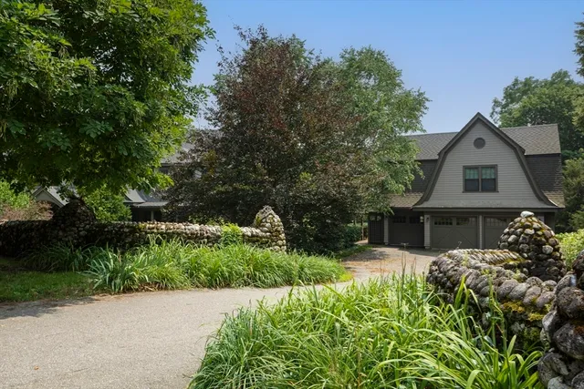 a front view of a house with a yard and potted plants