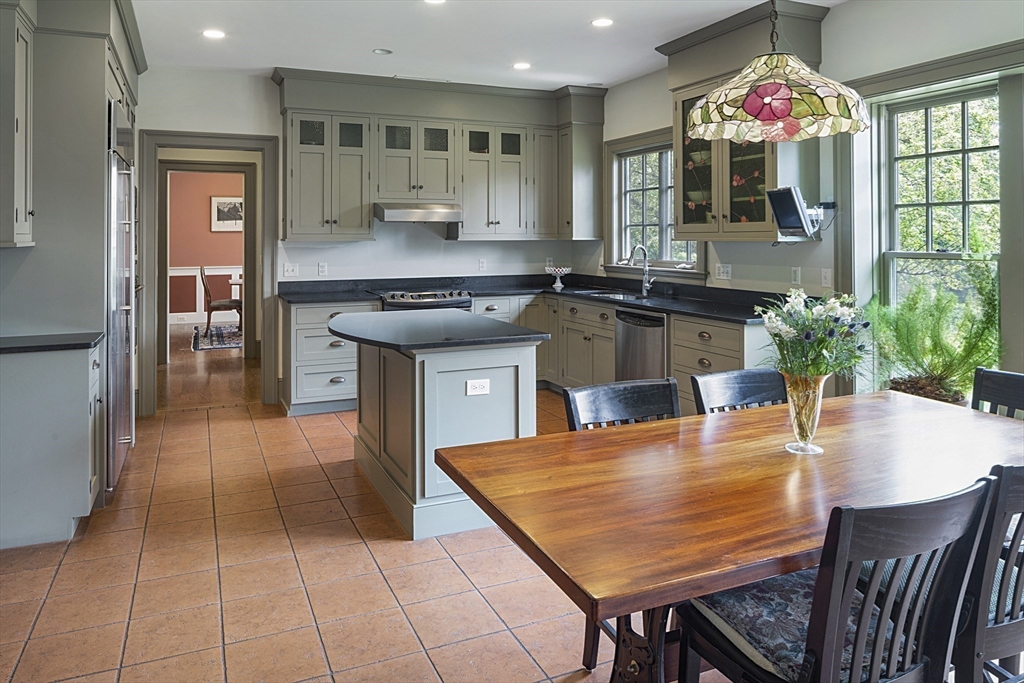 49 Willard Common Concord, MA 01742 - Photo 10 of 39 an open kitchen with granite countertop a stove a sink and a dining table