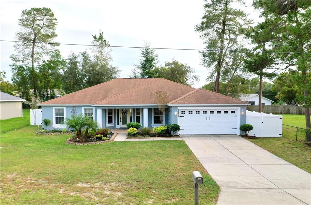 5262 Birchwood Road Spring Hill, FL 34608 - Photo 1 of 1 a front view of a house with garden