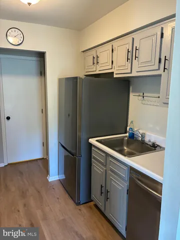 a kitchen with stainless steel appliances granite countertop a refrigerator a stove and a sink