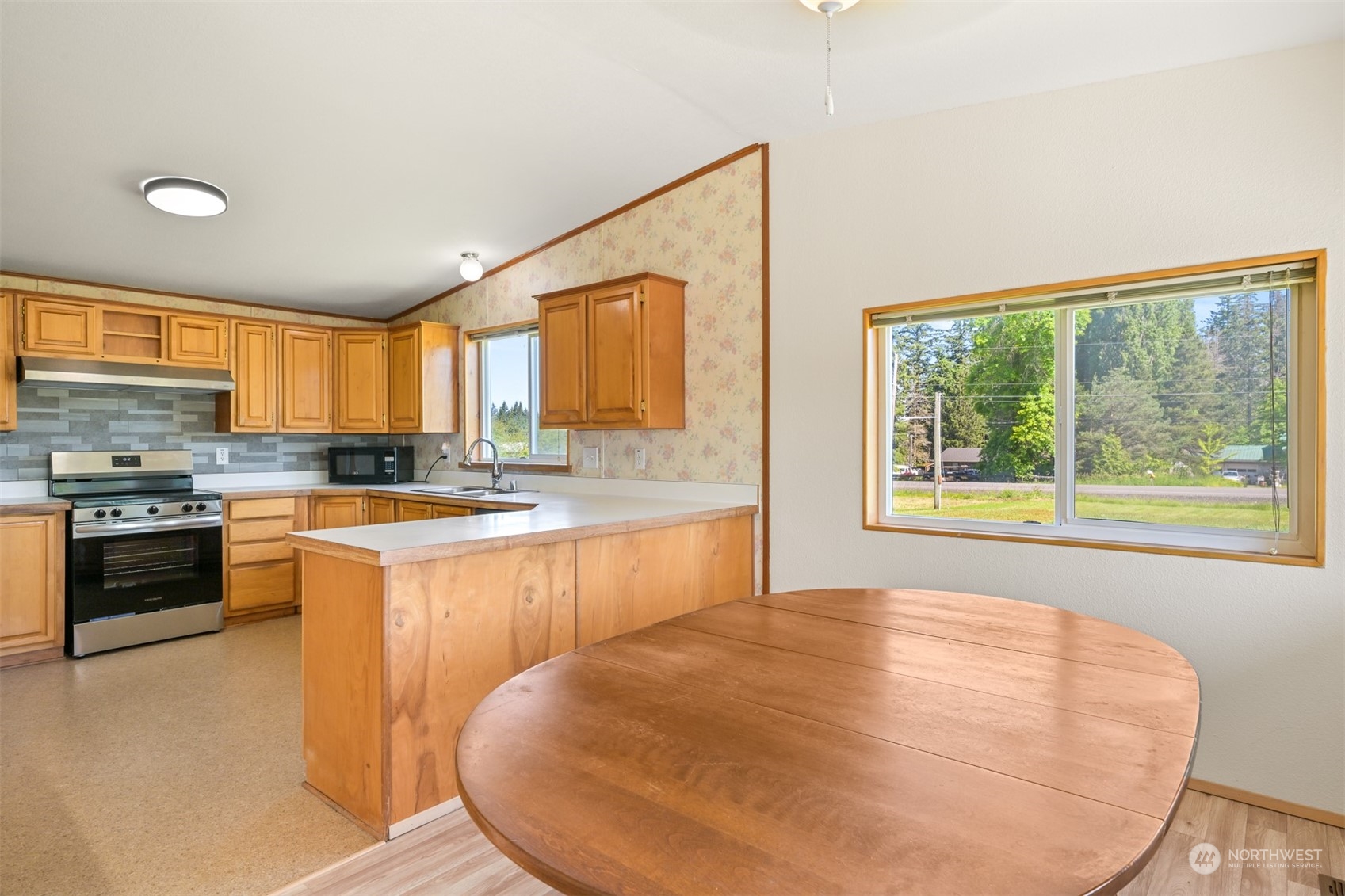 3323 East Smith Road Bellingham, WA 98226 - Photo 8 of 34 a large kitchen with stainless steel appliances granite countertop a stove a sink and a microwave