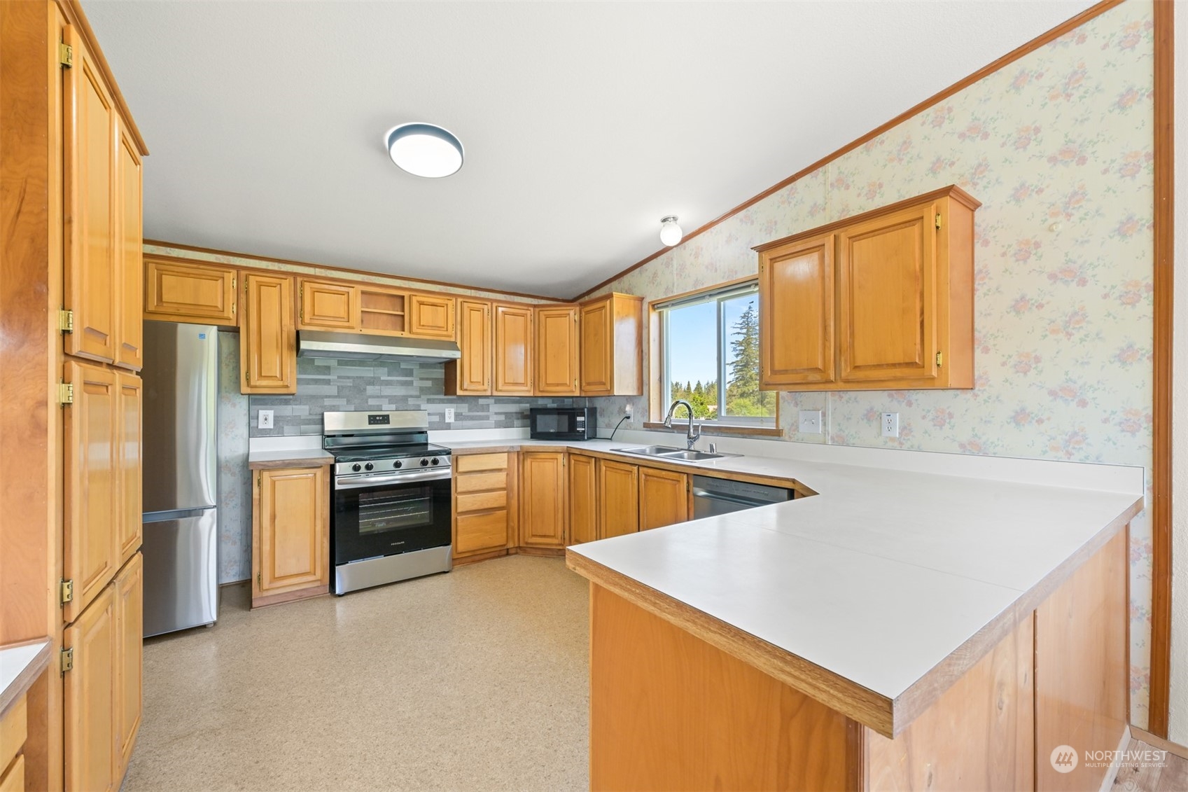 3323 East Smith Road Bellingham, WA 98226 - Photo 9 of 34 a kitchen with stainless steel appliances a sink window and cabinets