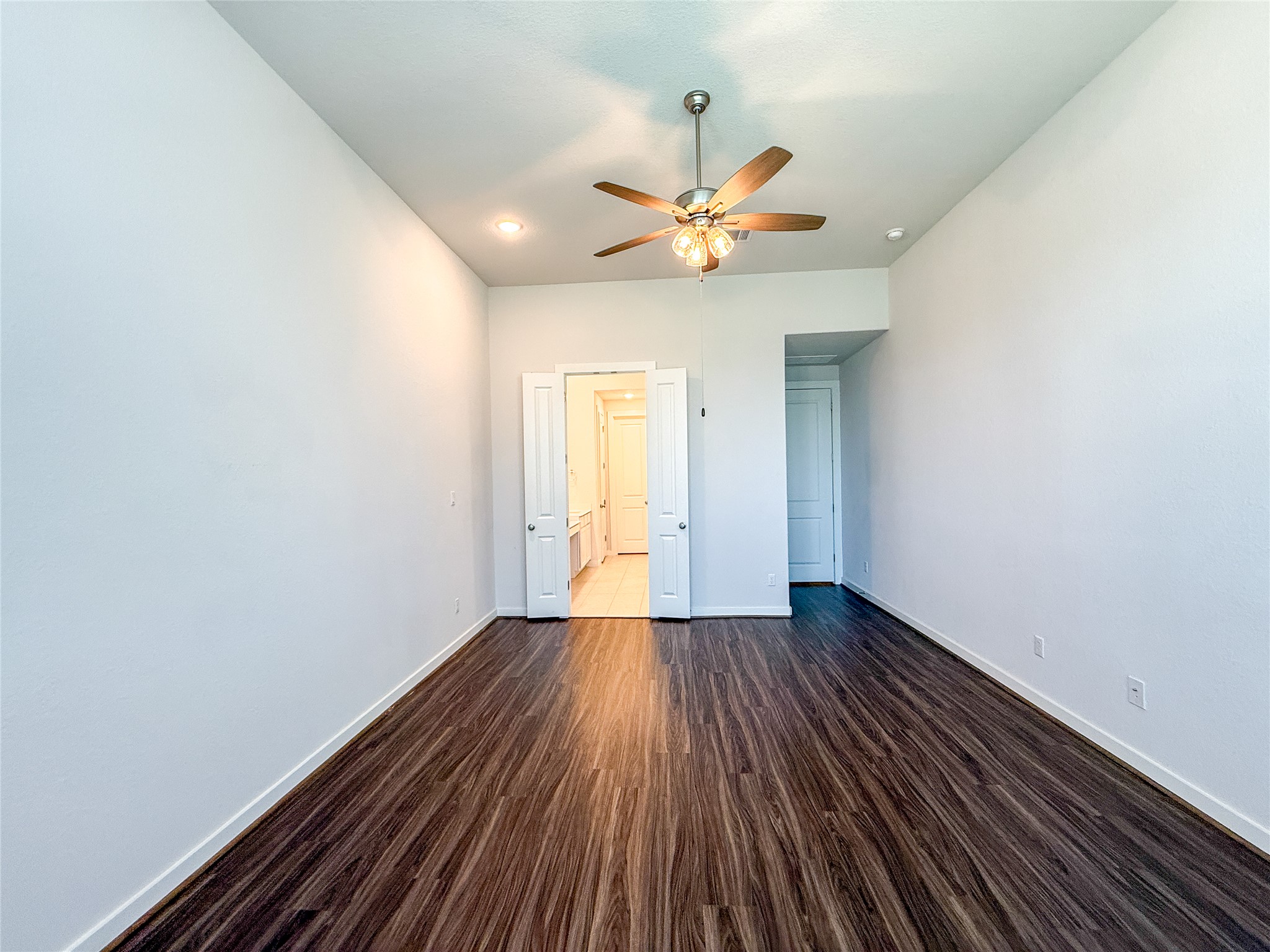 249 Heartleaf Road San Marcos, TX 78666 - Photo 17 of 38 A spacious bedroom featuring rich hardwood flooring and a stylish ceiling fan.