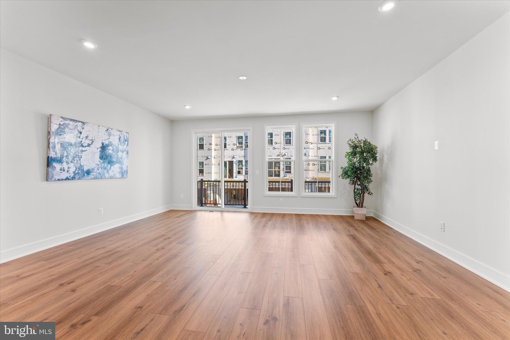 23080 Soaring Hts Terrace Ashburn, VA 20148 - Photo 10 of 44 a view of an empty room with a window and wooden floor