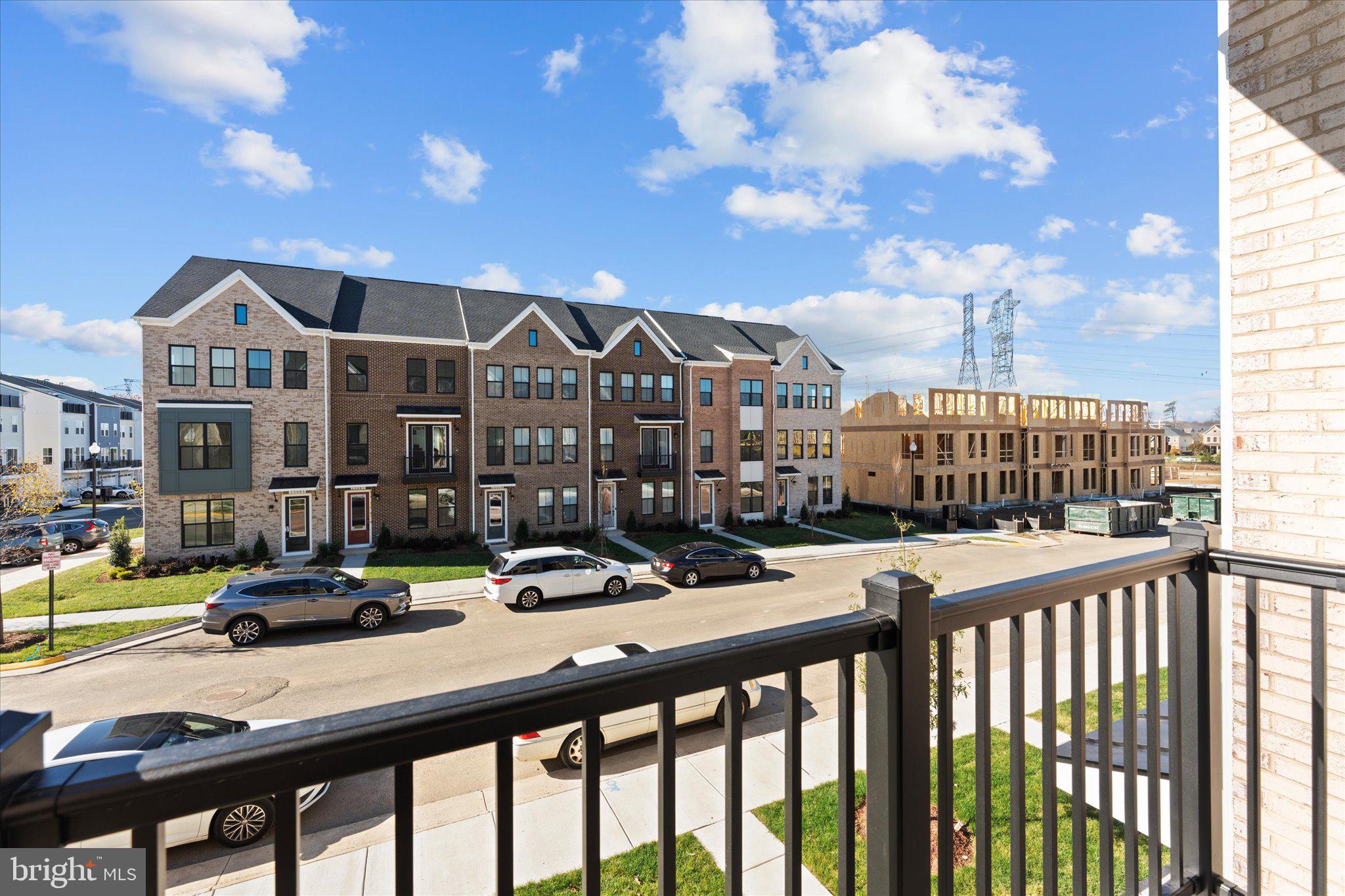 23080 Soaring Hts Terrace Ashburn, VA 20148 - Photo 20 of 44 a view of a brick house with large windows and more trees