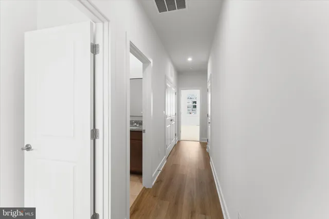a view of a hallway with wooden floor