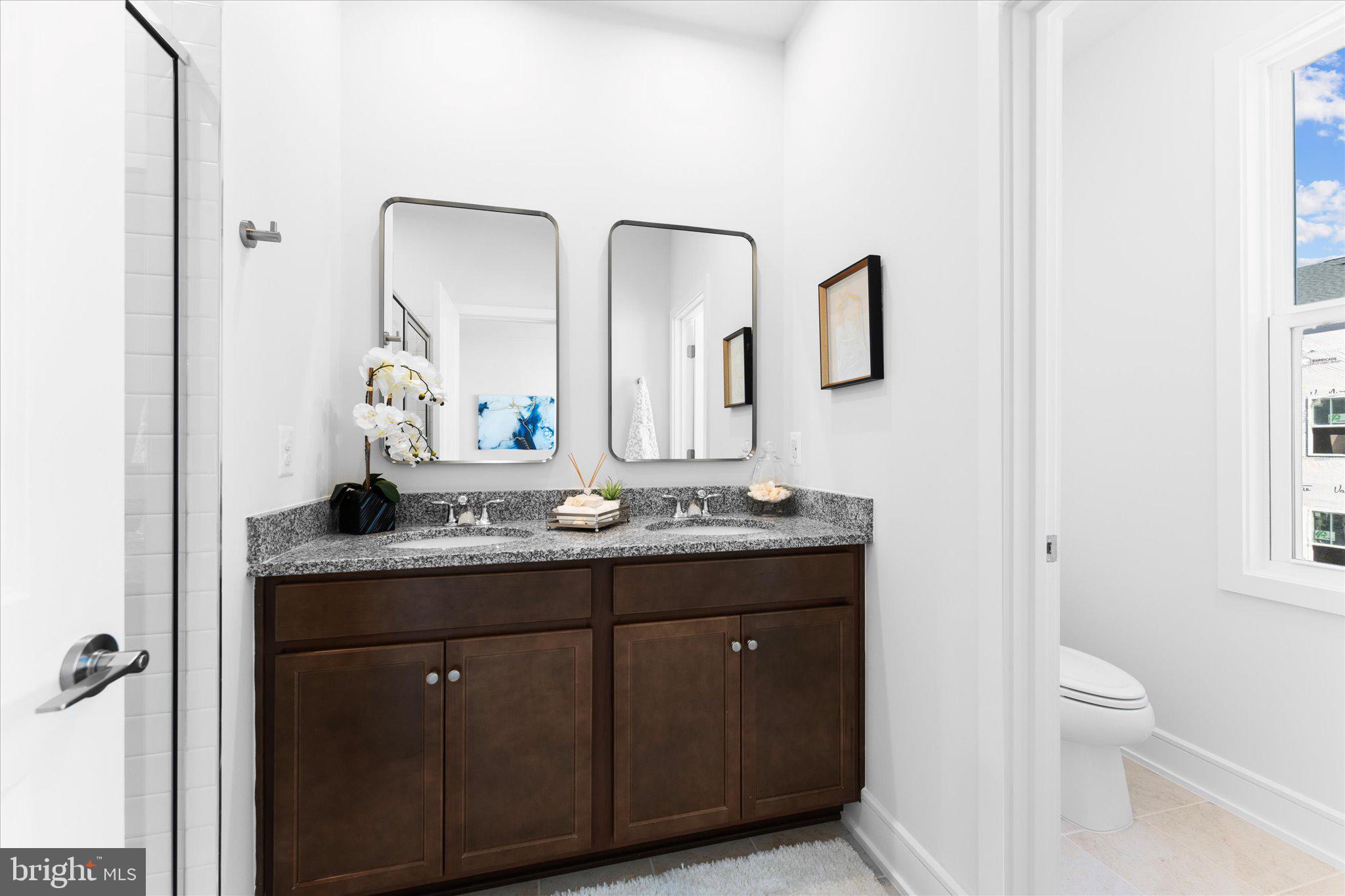 23080 Soaring Hts Terrace Ashburn, VA 20148 - Photo 28 of 44 a bathroom with a granite countertop sink a toilet and a mirror