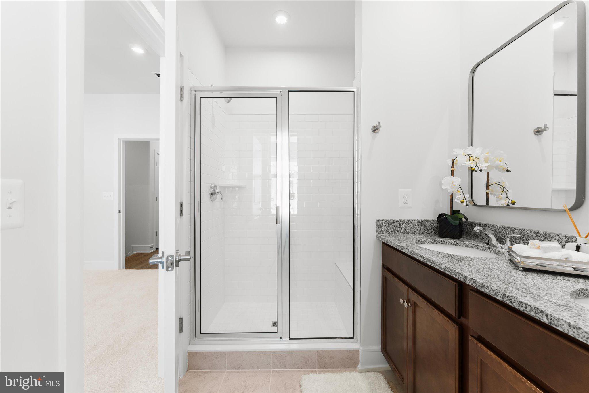 23080 Soaring Hts Terrace Ashburn, VA 20148 - Photo 29 of 44 a bathroom with a granite countertop sink a mirror and shower