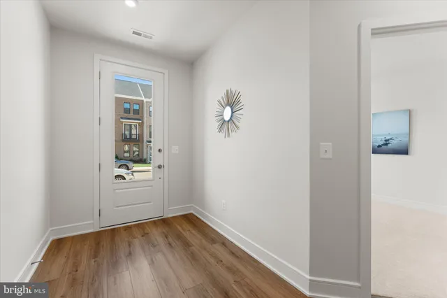 an empty room with a hardwood and hallway