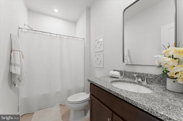 a bathroom with a granite countertop sink toilet and shower