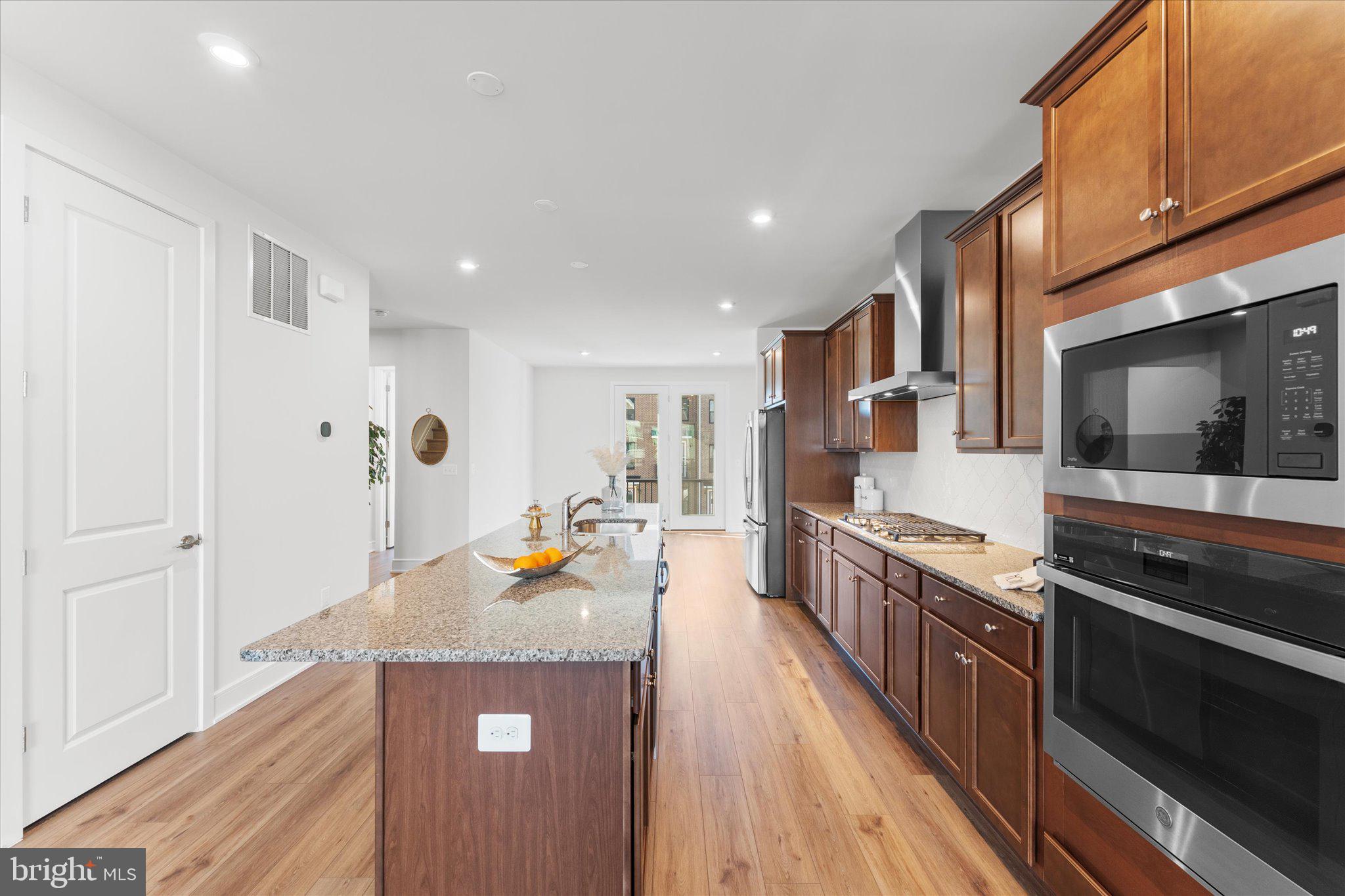 23080 Soaring Hts Terrace Ashburn, VA 20148 - Photo 6 of 44 a kitchen with stainless steel appliances granite countertop a stove and a wooden floors