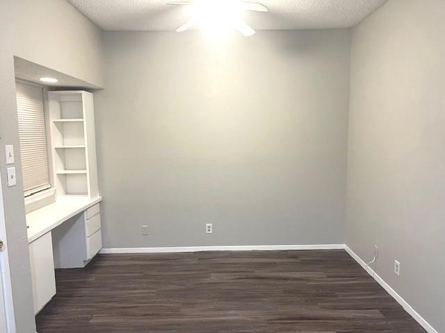 3316 Guadalupe Street, Unit 209 Austin, TX 78705 - Photo 2 of 12 Unfurnished dining area featuring dark wood-style flooring, built in study area, and a textured ceiling