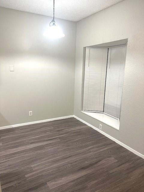 3316 Guadalupe Street, Unit 209 Austin, TX 78705 - Photo 4 of 12 Empty room featuring a textured ceiling and dark wood finished floors